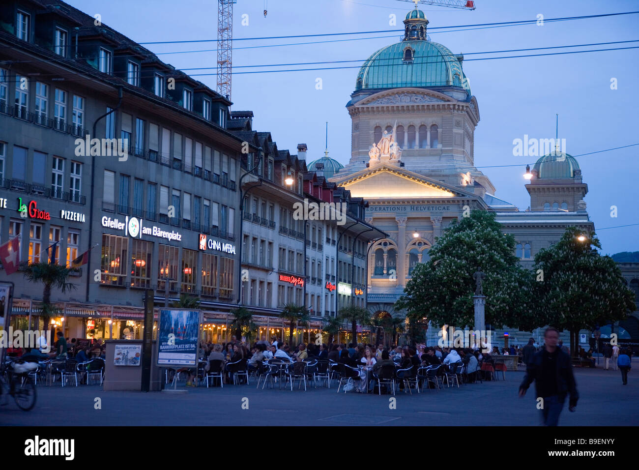 Guests sitting in pavement cafes at Bärenplatz in the evening Federal Palace in background Old Town Berne Stock Photo