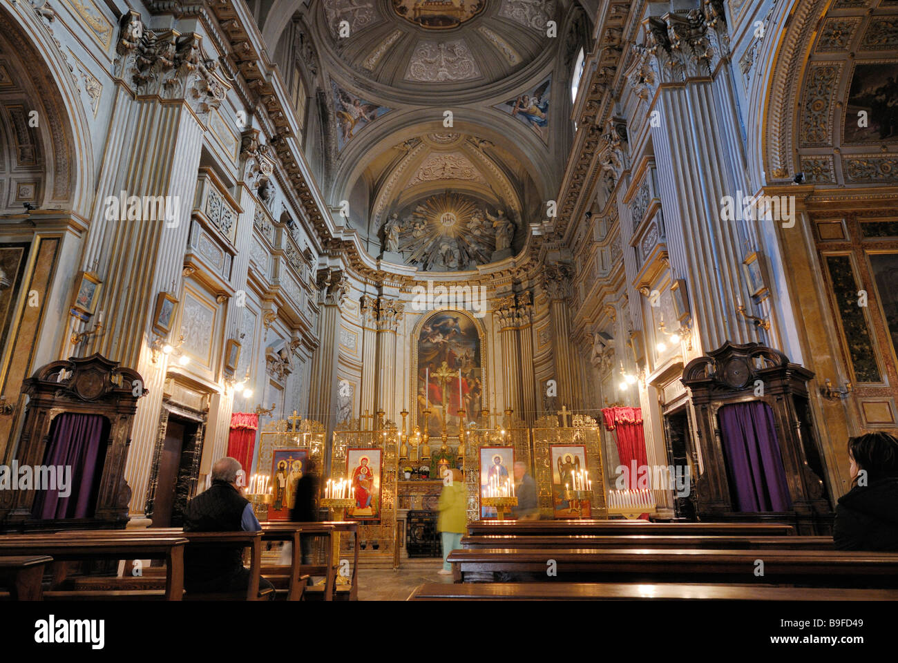 Three people praying in church, Santi Vincenzo e Anastasio, Rome, Latium, Italy Stock Photo