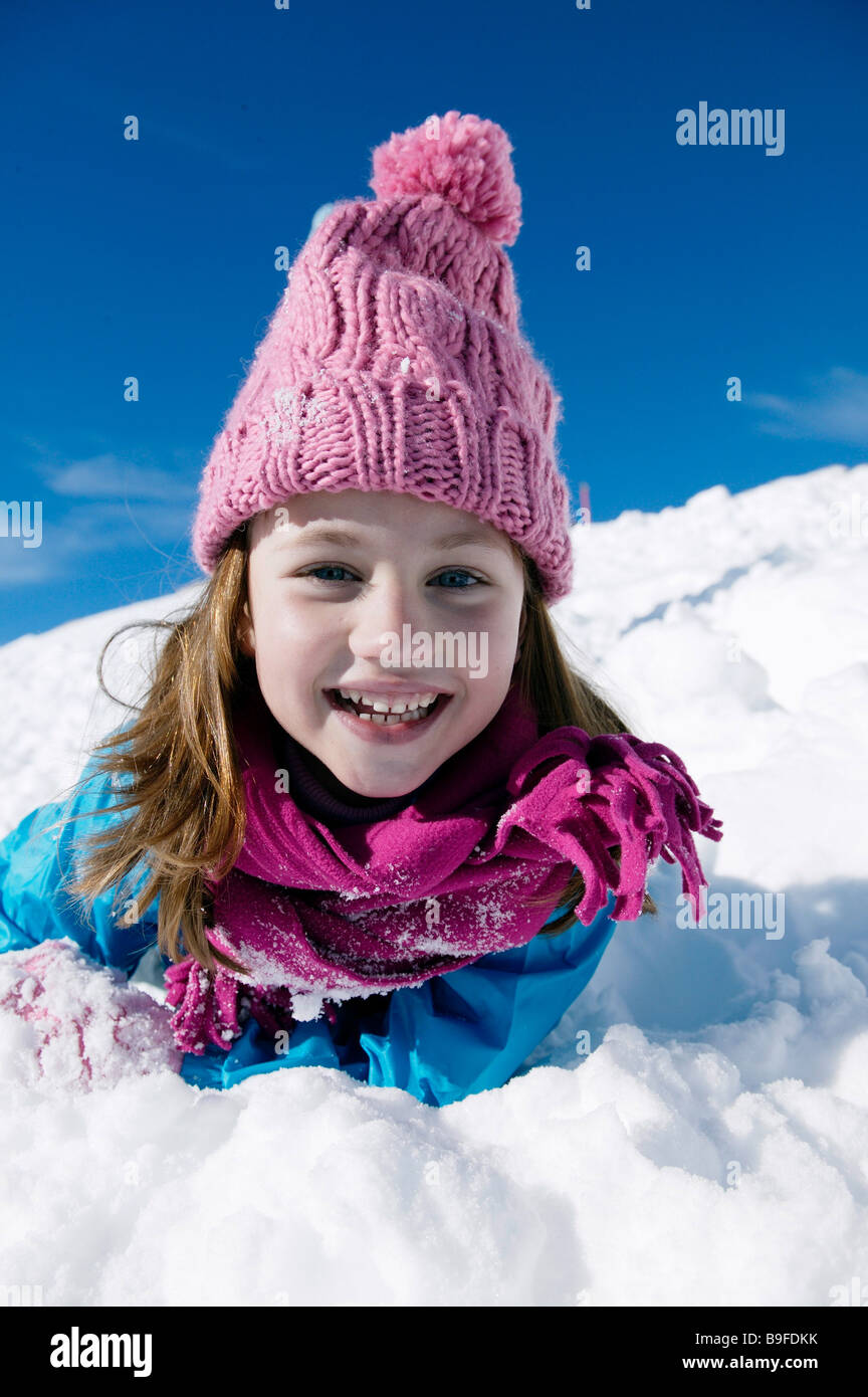 Portrait of girl lying on snow and smiling Stock Photo - Alamy