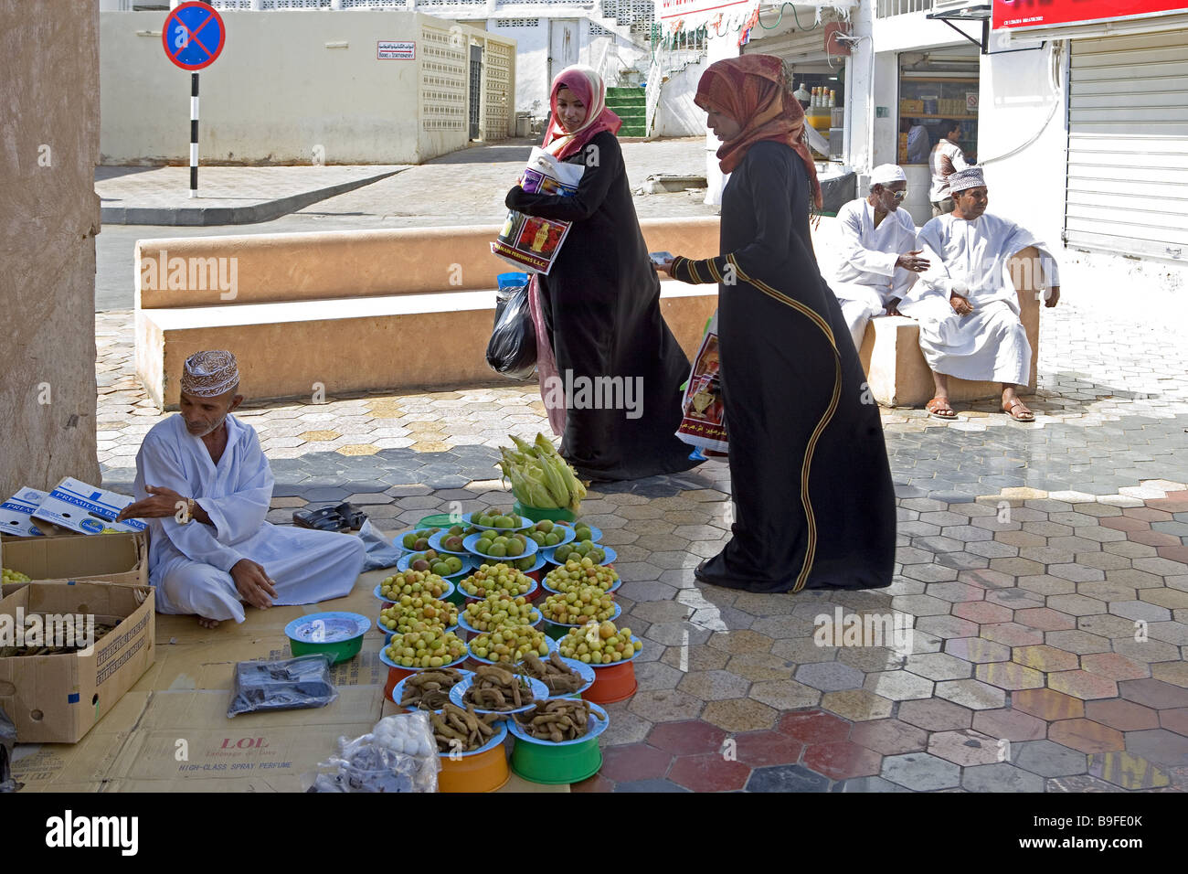 Oman Muscat Mutrha Souk hawkers customers sultanate city capital alley people merchants sale buys food women kerchiefs natives Stock Photo
