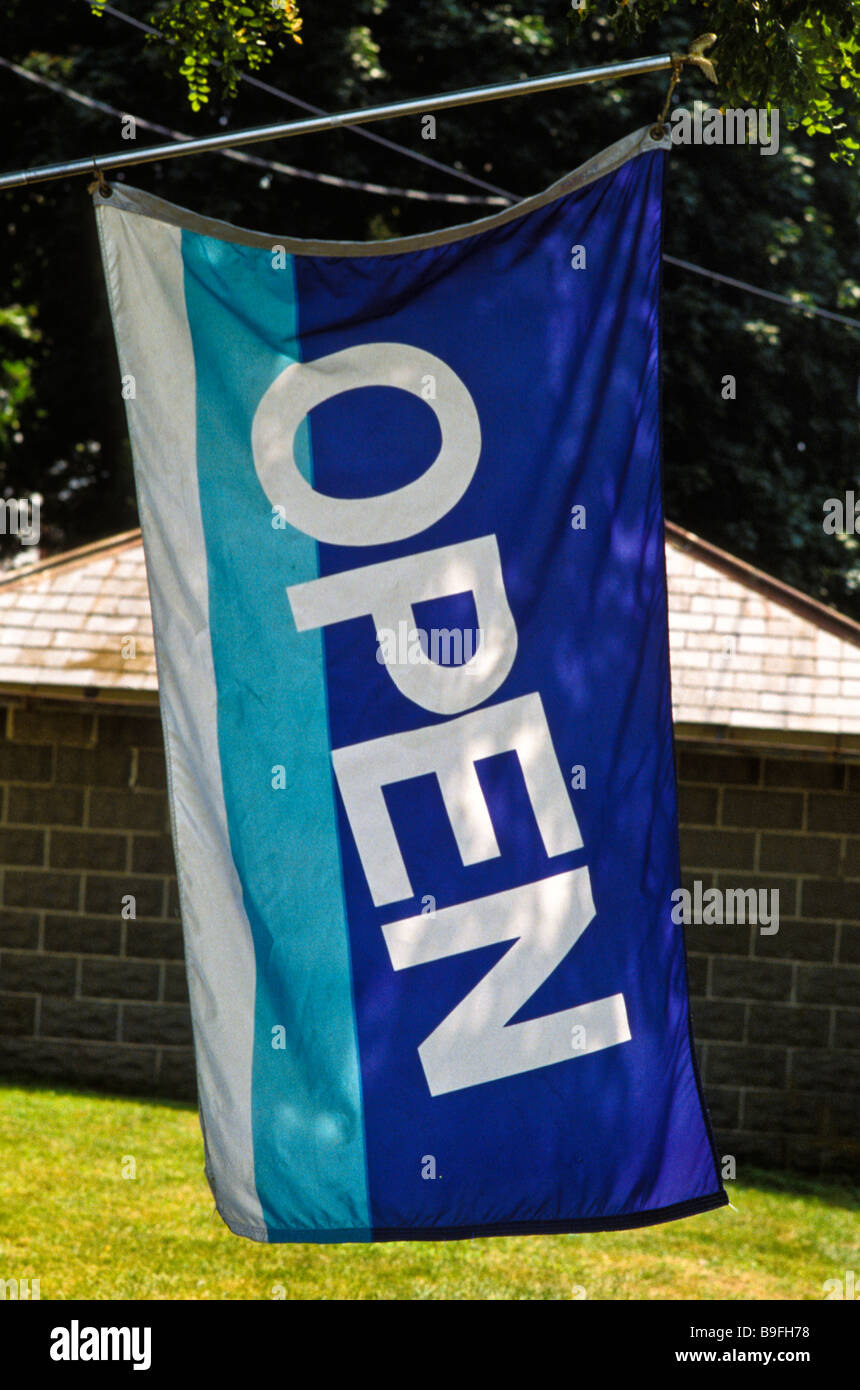 blue white open sign flag on tree of antique crafts souvenier store