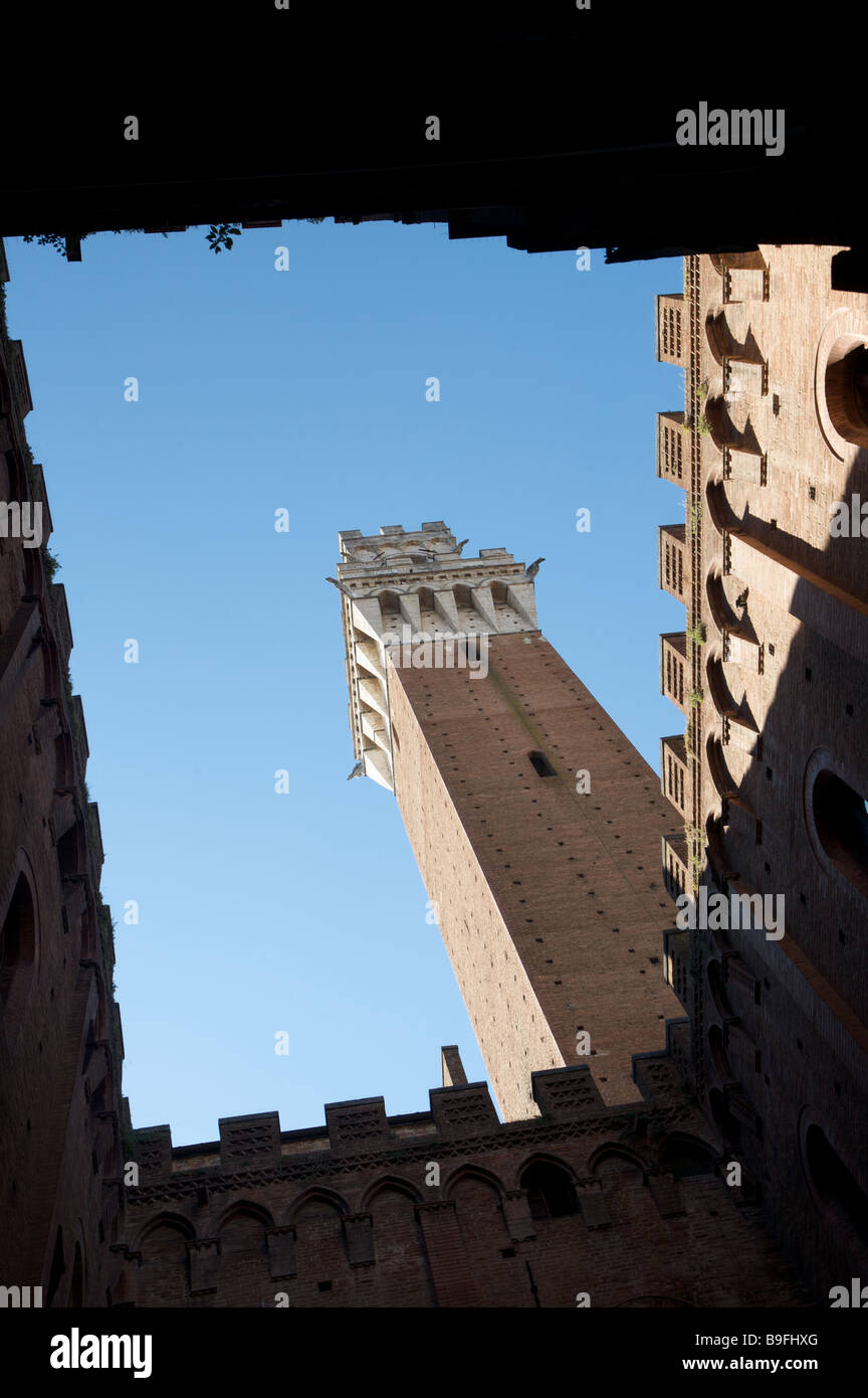 The view upwards to a blue sky from inside the La Torre del Mangia courtyard in Piazza del Campo Siena Italy Stock Photo