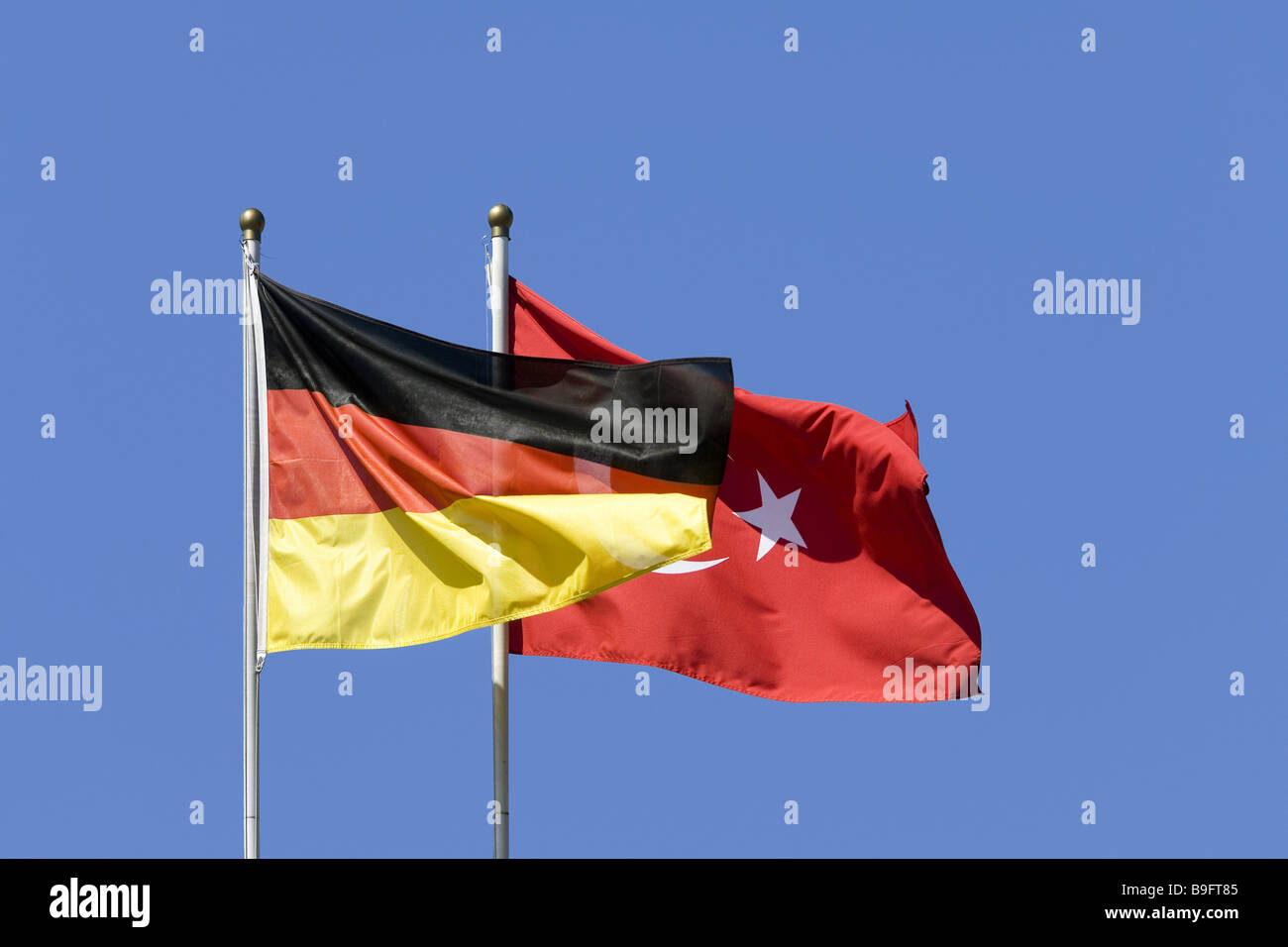 flagpoles flags German Turkish wind blows flags flagpole nationalities Germany Turkey politics Europe symbol Stock Photo