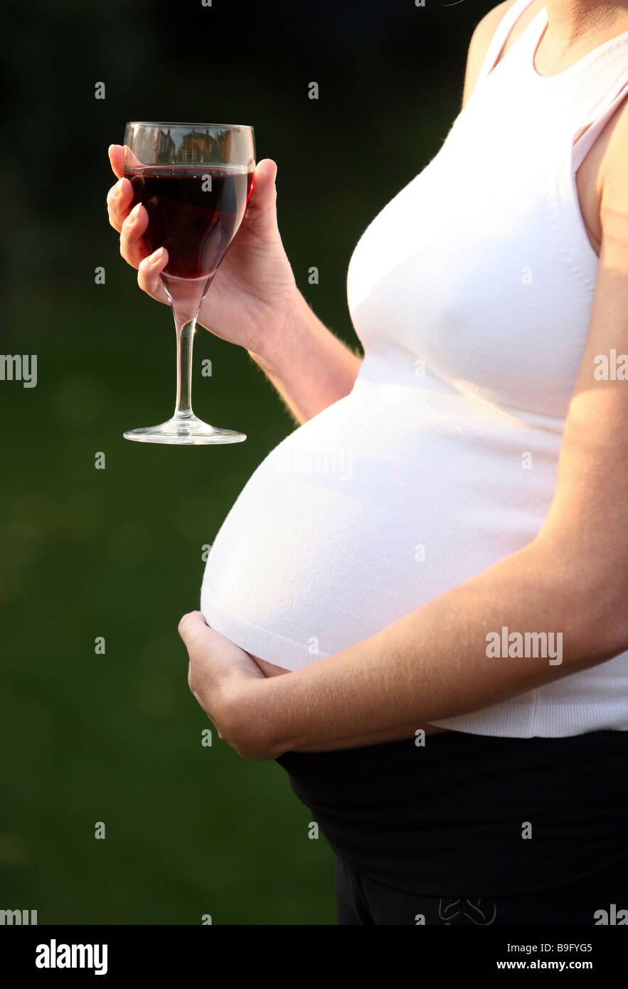 A pregnant woman with a glass of red wine Stock Photo Alamy