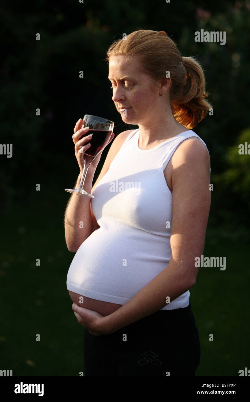 A pregnant woman with a glass of red wine Stock Photo Alamy