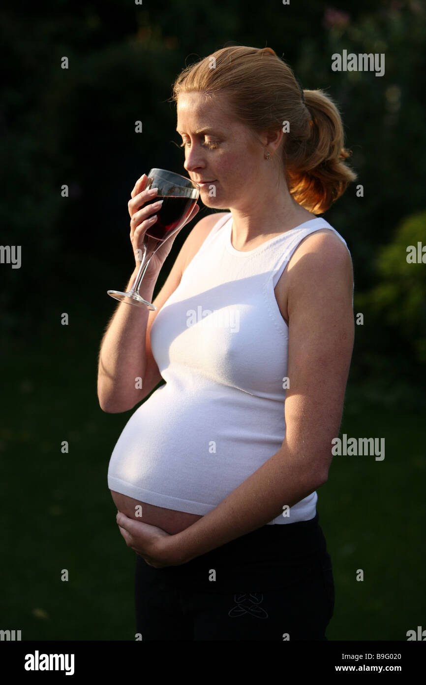 A pregnant woman with a glass of red wine Stock Photo Alamy