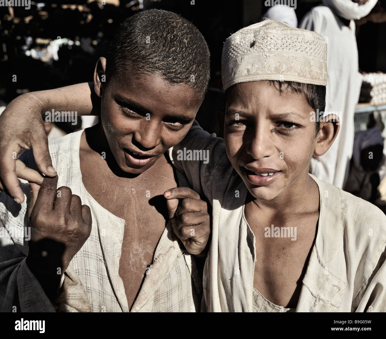 Two boys in Sudan, friends holding hands. One is African, one is Arabic