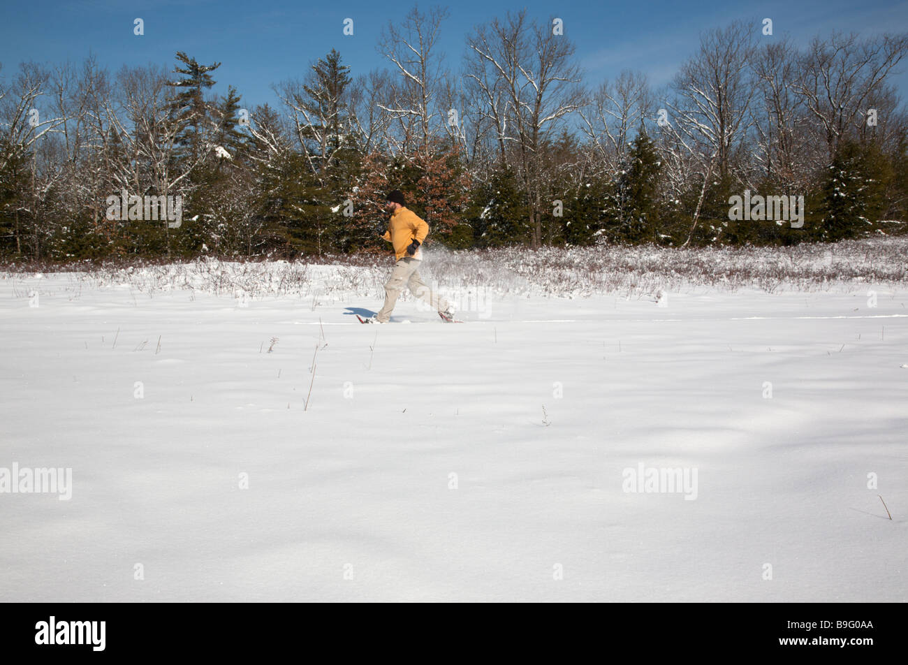 A man snowshoeing on a trail during the winter months in Fremont New
