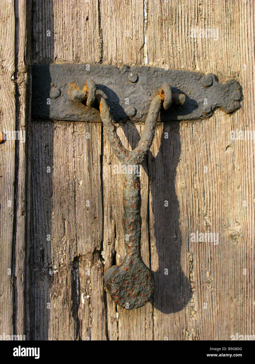 Medieval door knocker come handle from an ancient door, very rusted