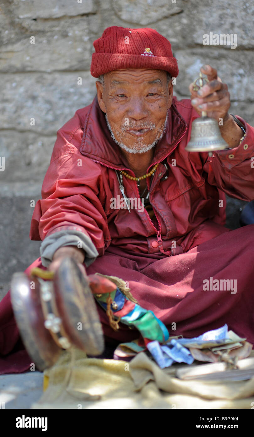 Bhutanese monk praying and singing with prayer drum Stock Photo