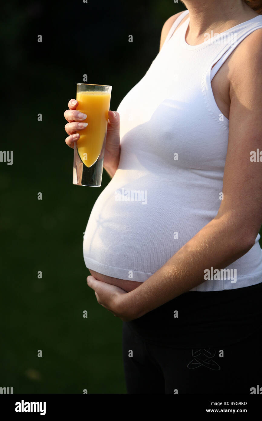 A pregnant woman with a glass of orange juice Stock Photo - Alamy