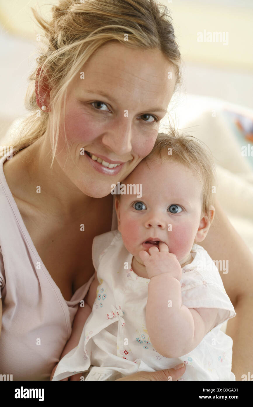 Mother baby smiling expression head-on portrait 20-30 years 5 months attention baby guarding gaze camera development fingers in Stock Photo