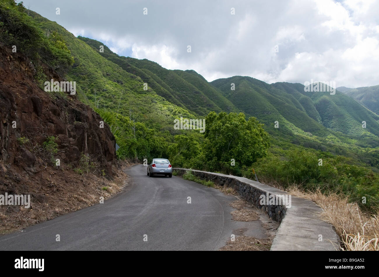Car on narrow section of Highway 450 East through Halawa Valley