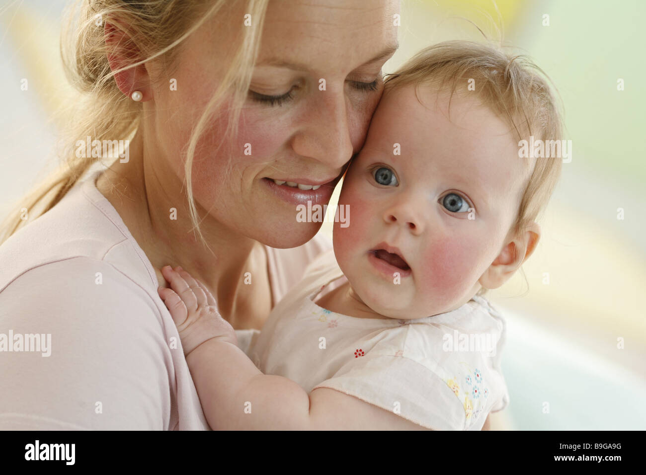 Mother baby embraces smiling portrait  20-30 years 5 months broached wakened alertly attention baby guarding adherence woman Stock Photo