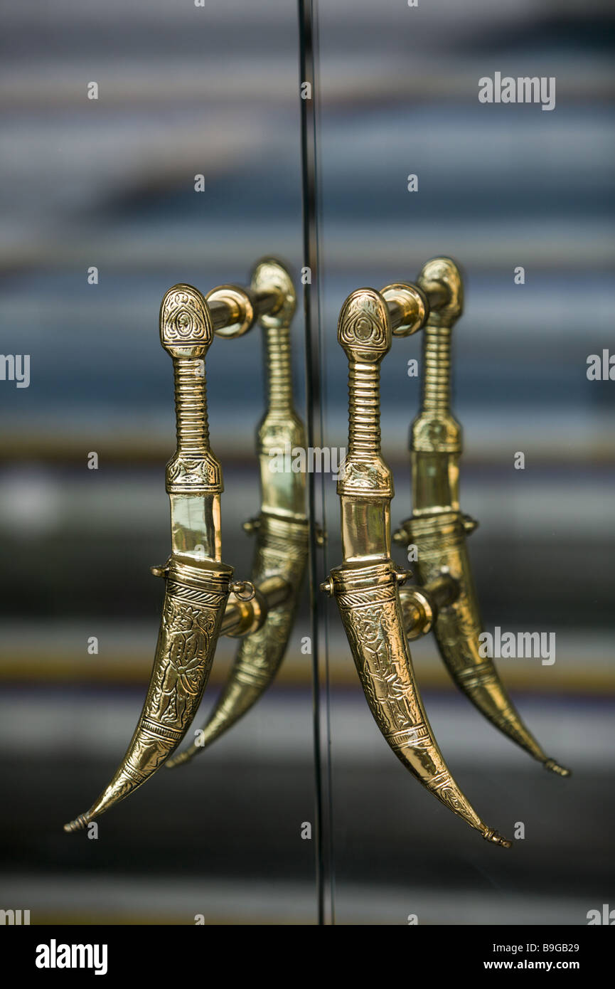 Glass-door detail handle sabers golden door glass glass entrance doorknob swords daggers sheath transparent reflection four Stock Photo