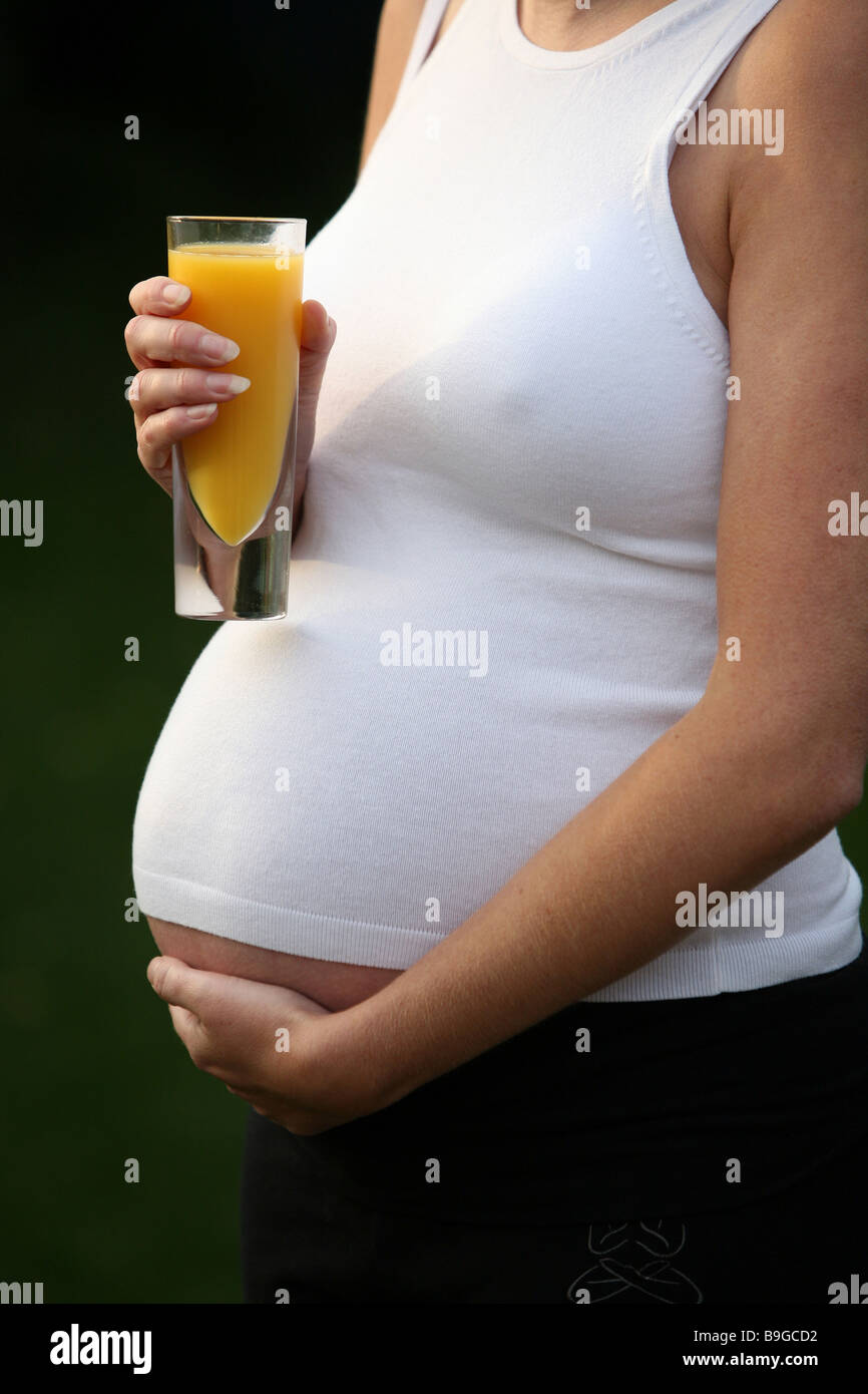 A pregnant woman with a glass of orange juice Stock Photo - Alamy