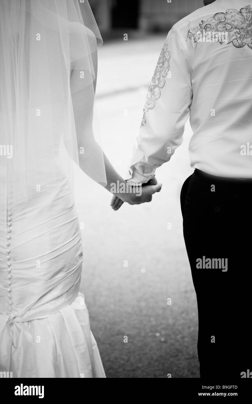 bride and groom walk away holding hands Stock Photo - Alamy