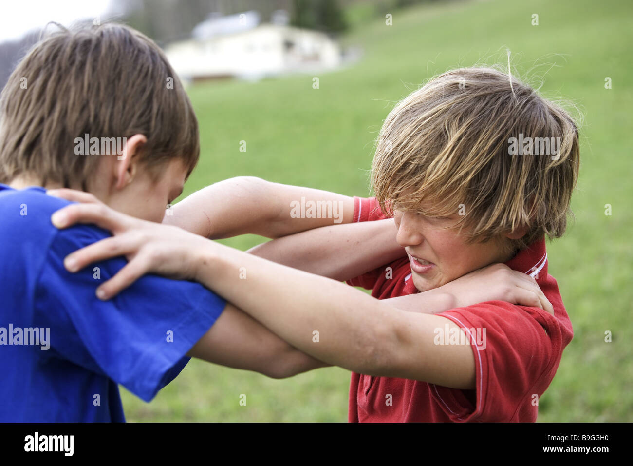 Meadow boys fights sidewards people 11-13 years children two childhood friends enemies dispute wrangling fight brawls rivals Stock Photo