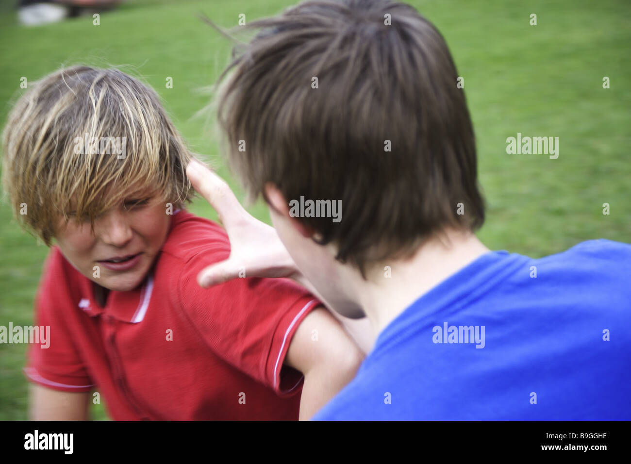 Meadow boys fights sidewards people 11-13 years children two childhood friends enemies dispute wrangling fight brawls rivals Stock Photo