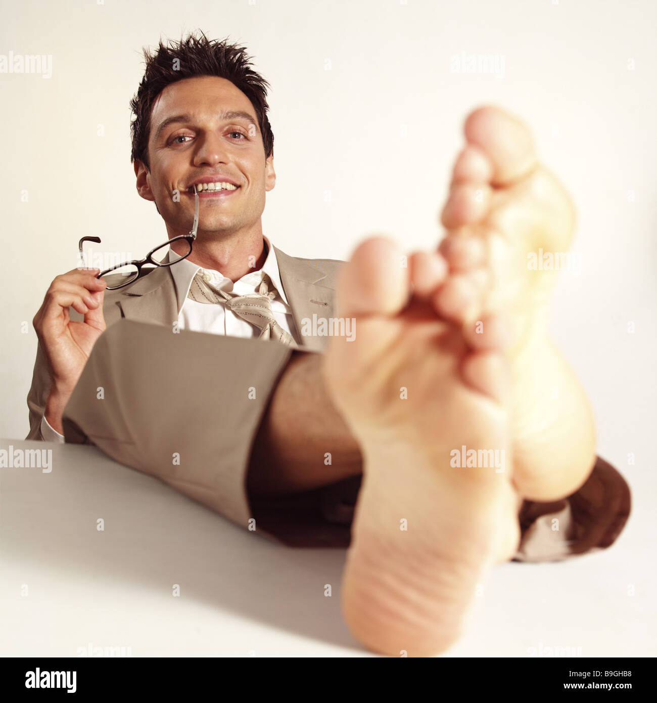 Managers barefoot feet puts up smiling contentment series desk table