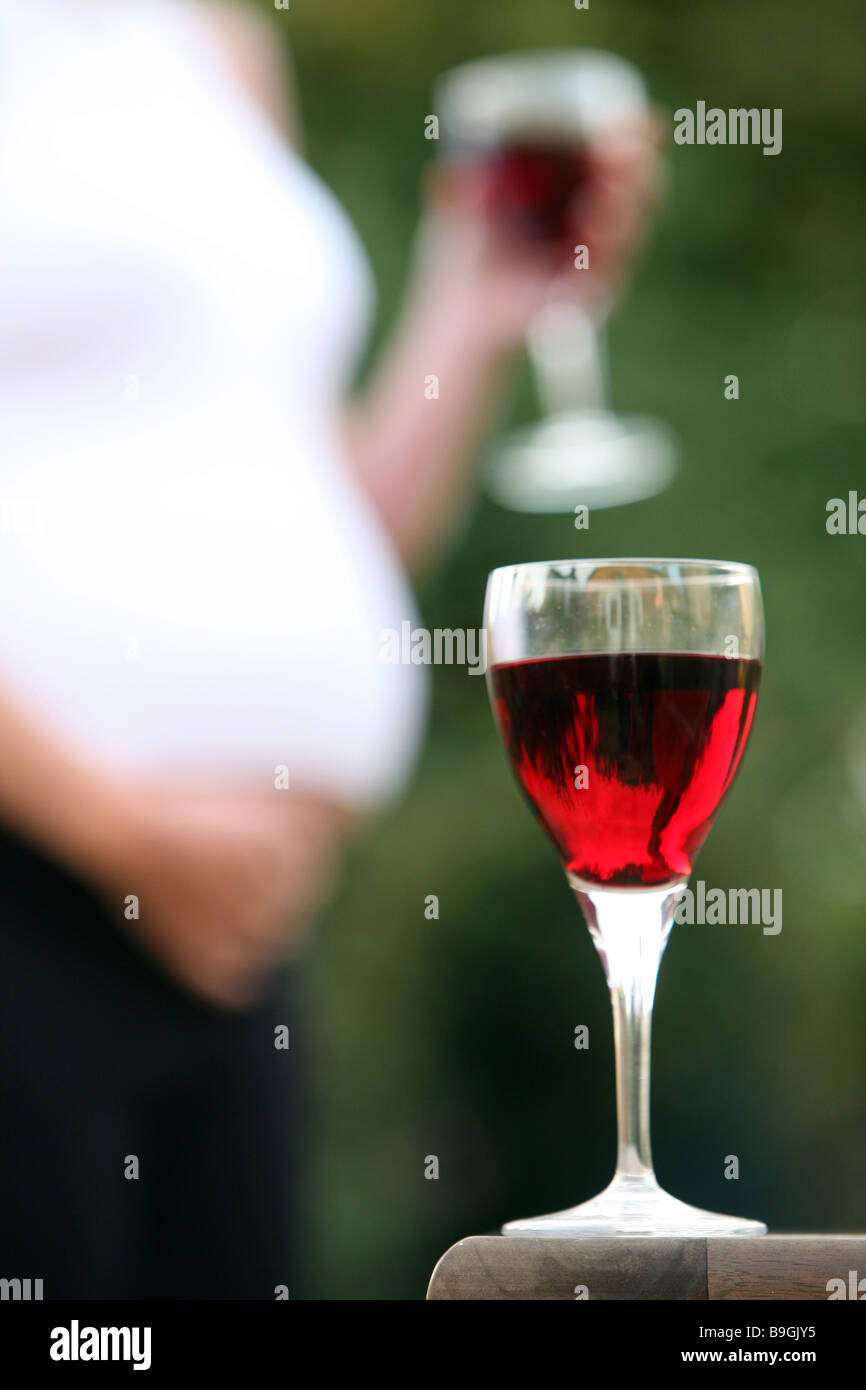 A glass of wine with a pregnant woman in the background Stock Photo Alamy