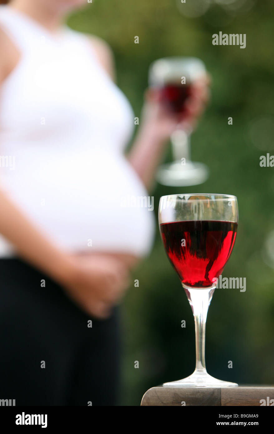A glass of wine with a pregnant woman in the background Stock Photo Alamy