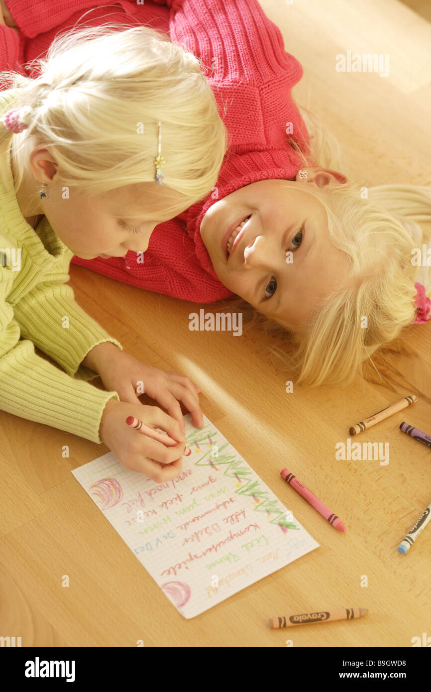 Children girl two wish lists writing 5-10 years advent listing enumeration blond joy cheerfully floor gift-list siblings inner Stock Photo