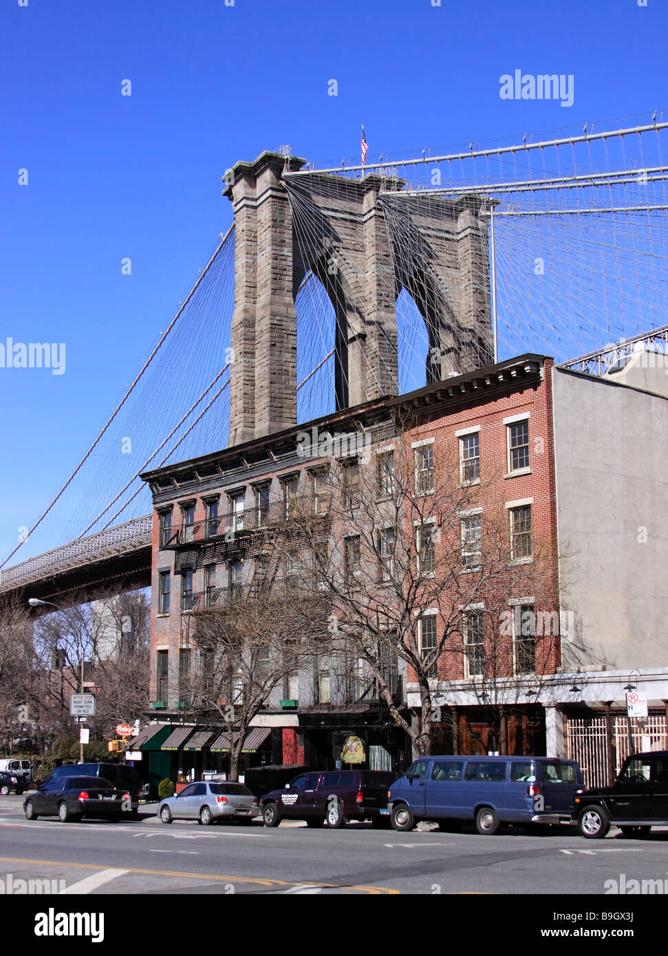 The Brooklyn Bridge towers over old apartment houses on Fulton Street