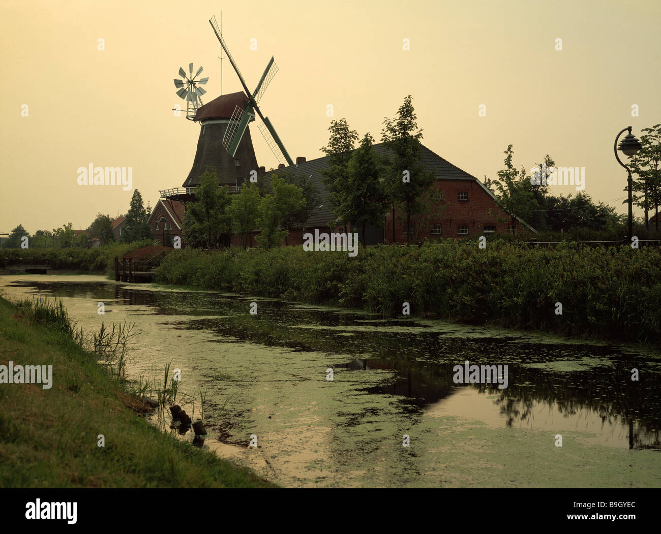 Germany East Frisia Ostgroßefehn canal windmill 1804 dusk Lower Saxony village house pack-house brick-house brick-buildings Stock Photo