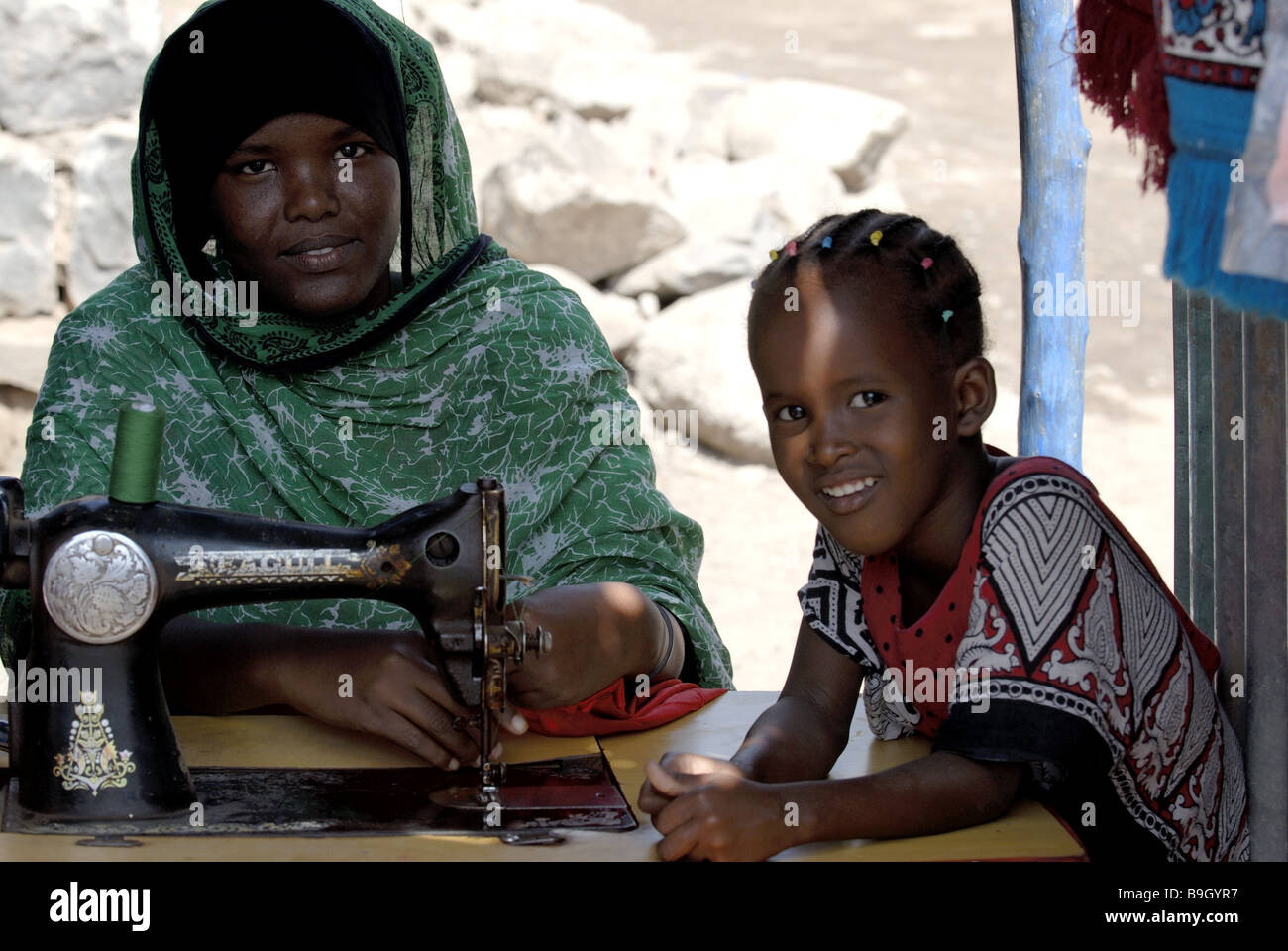 Dschibuti woman sewing machine sews girl watching detail Africa north-east-Africa Djibouti people natives swarthy kerchief Stock Photo