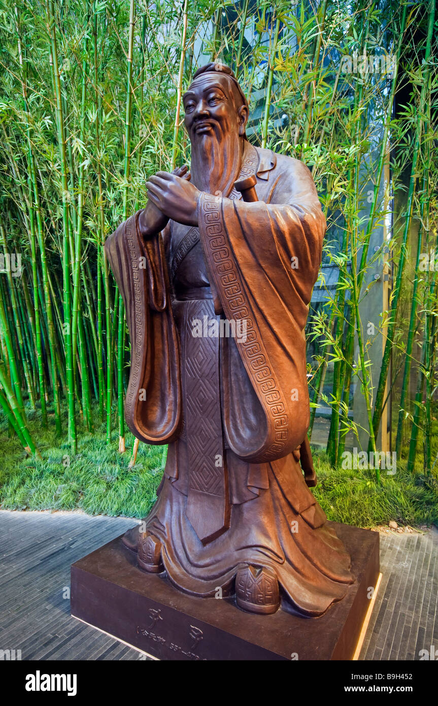 China, Beijing, Capitol Museum. A statue of Confucius surrounded by bamboo Stock Photo