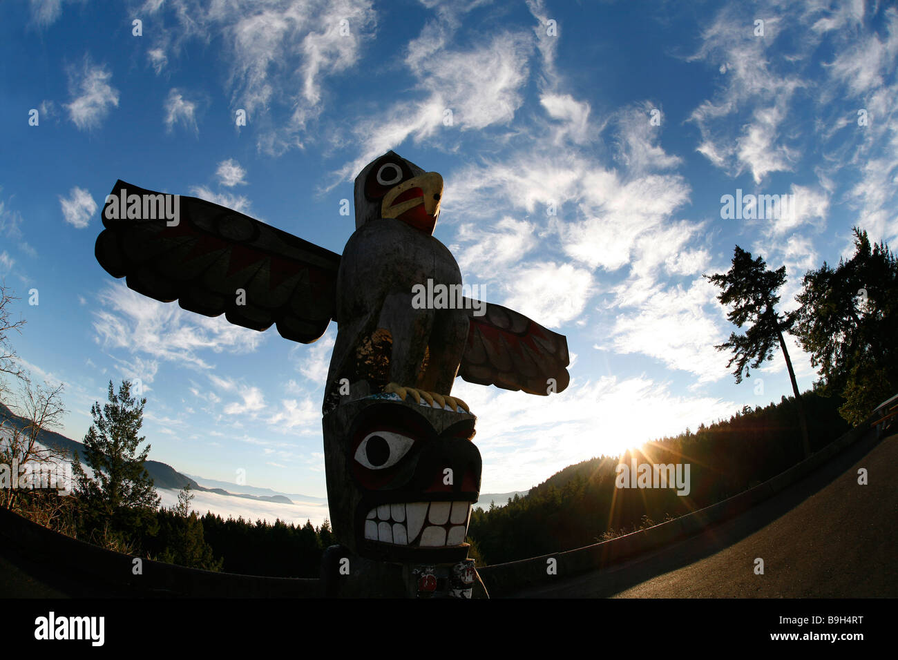A totem pole at the Malahat Summit overlooking the Saanich Inlet at sunset on Vancouver Island, Canada. Stock Photo