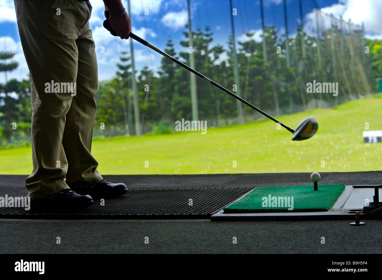 A man hitting golf balls at a driving range Stock Photo Alamy