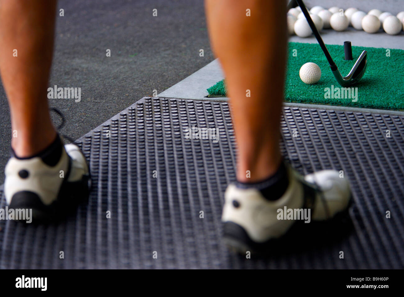 A man hitting golf balls at a driving range Stock Photo Alamy