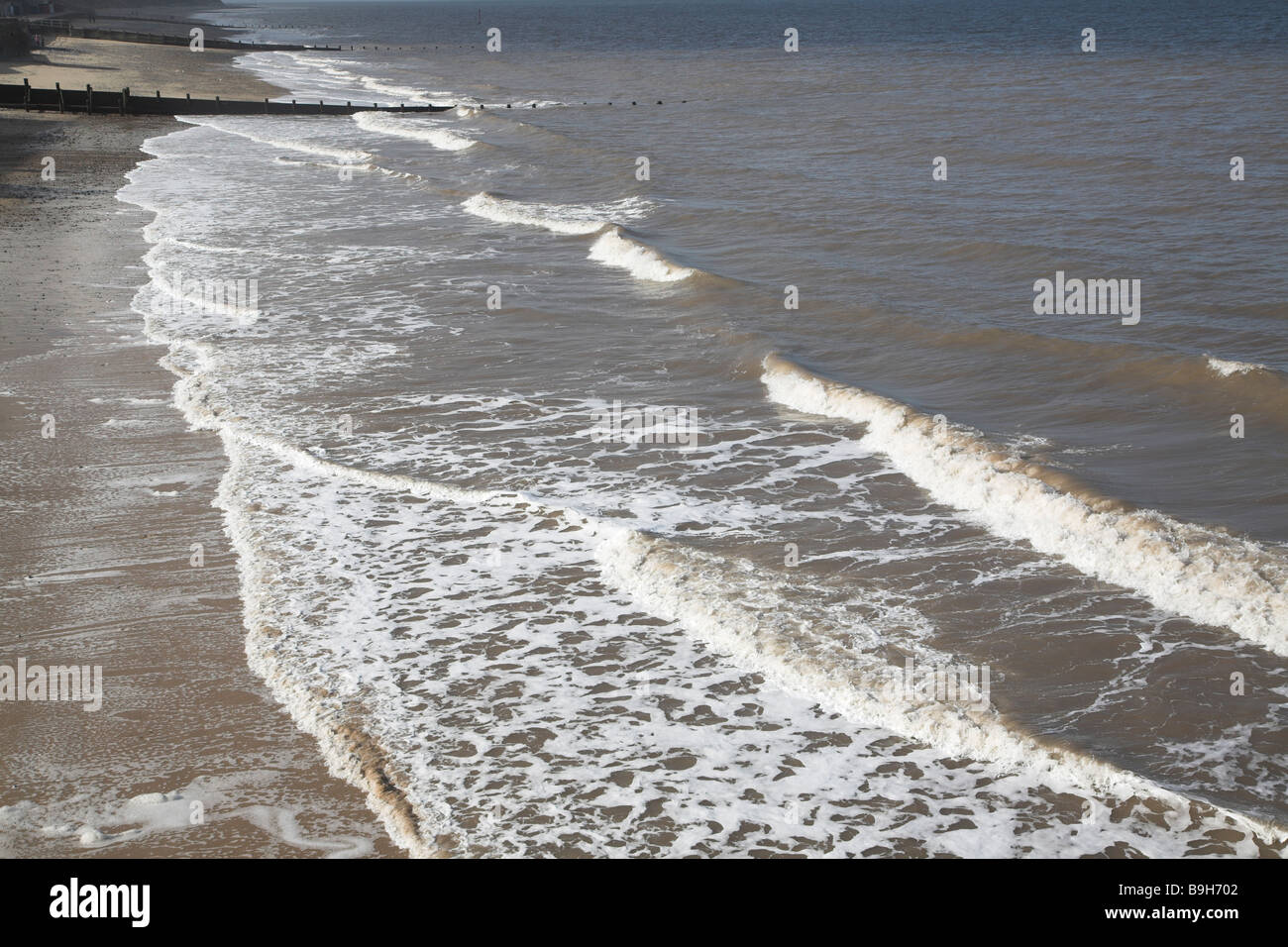 Waves break on beach Cromer Norfolk England Stock Photo
