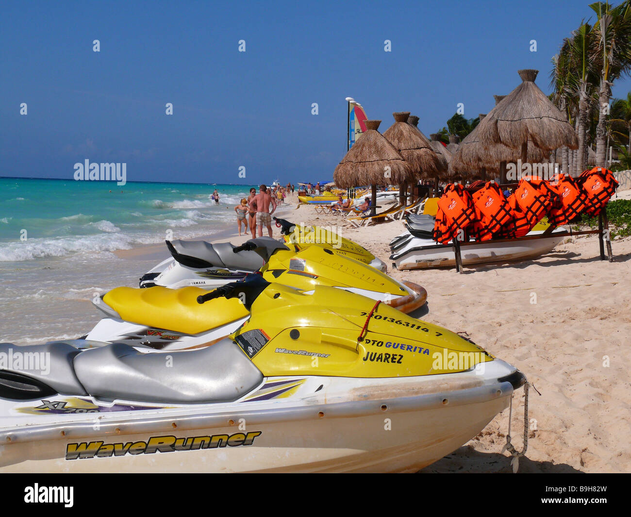 Mexico Yucatan Playa Del Carmen beach Jetskier shore parasols deck chairs swimmers lake Latin