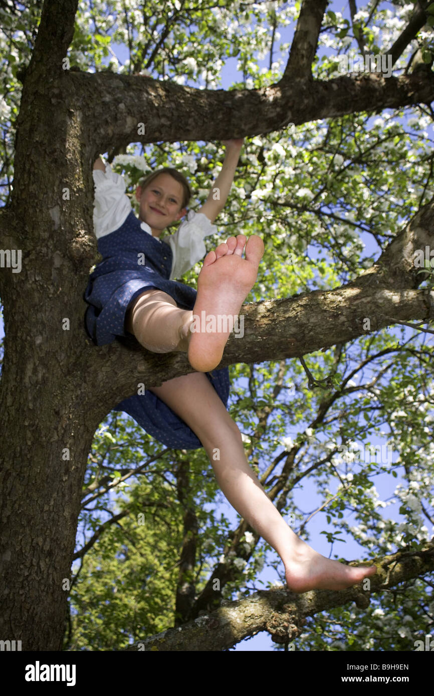 girl tree play climbs 13 years activity activity branch outside barefoot  tree blossom legs movement spread blooms Dirndl Stock Photo - Alamy