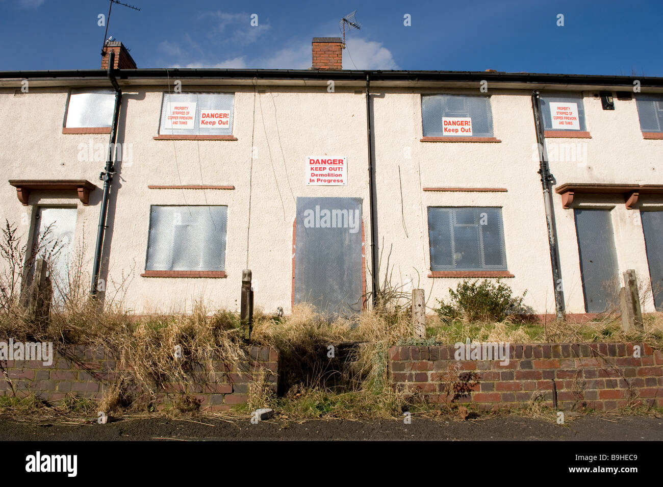 A row of empty derelict houses on a derelict housing estate near