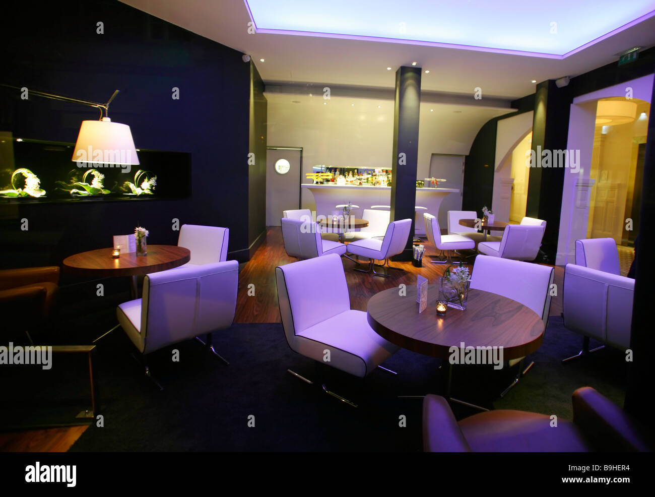 Stylish lounge bar with white chairs and ambient lighting Stock Photo