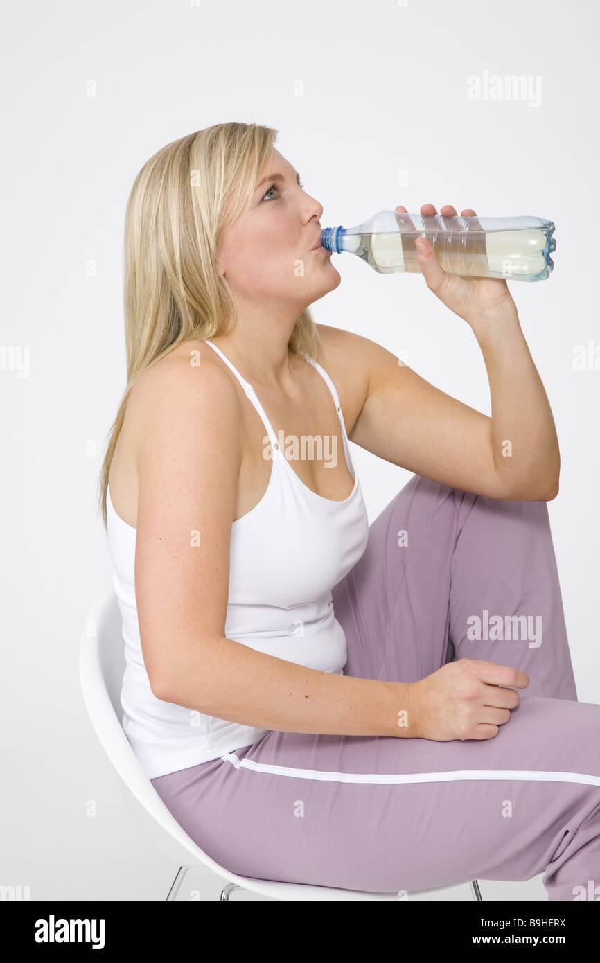 woman young cozy chair sitting bottle drinks at the side series people 30-40 years blond long-haired stout overweight jogging Stock Photo