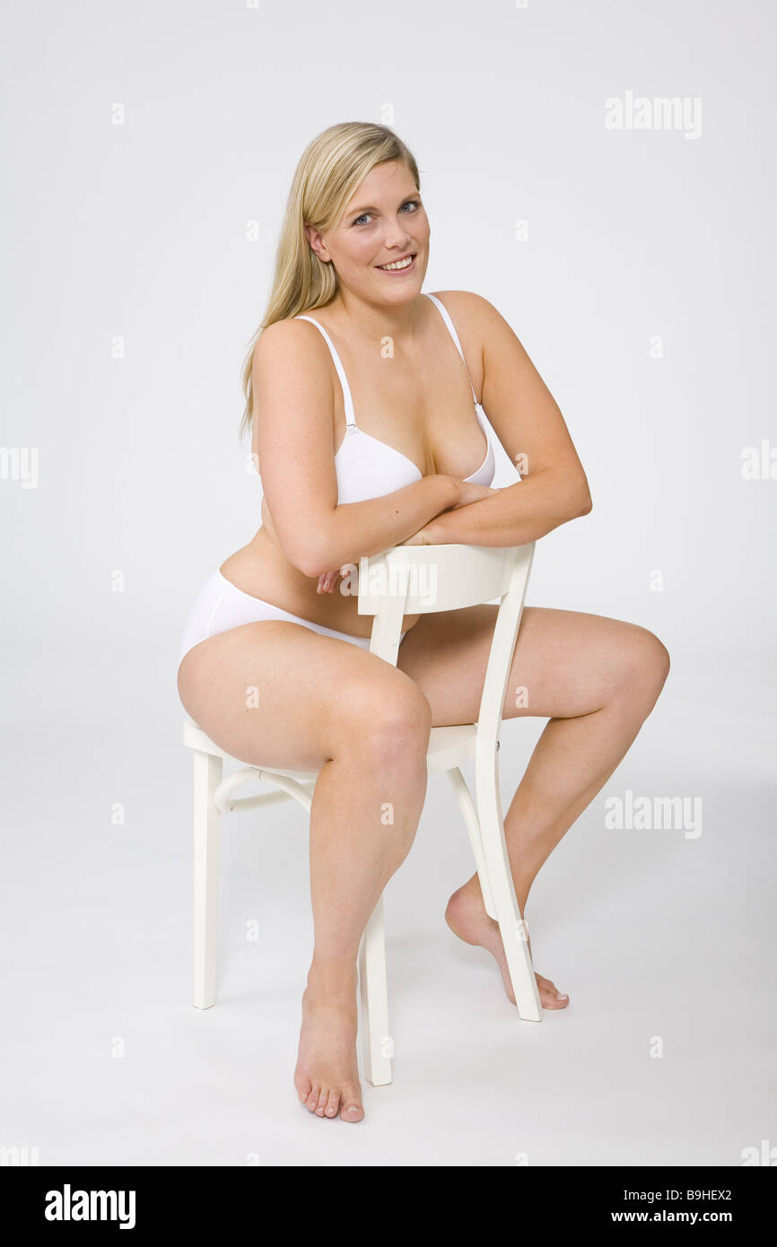 Sits woman young cozy underwear chair series people 30-40 years overweight  stout quite-body studio bra knows panties blond Stock Photo - Alamy