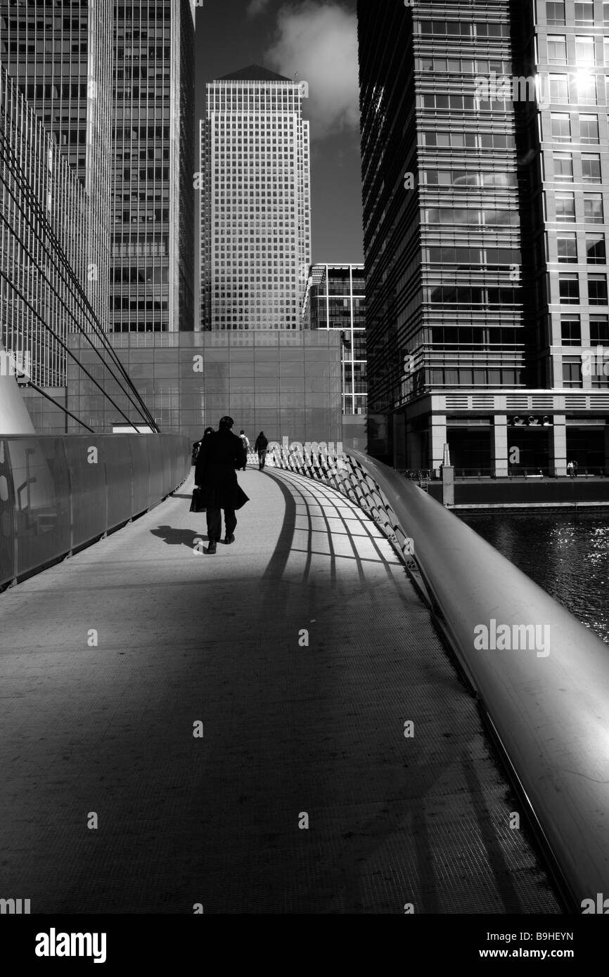 Pedestrians walking across the footbridge over West India Dock South, Canary Wharf, London Stock Photo