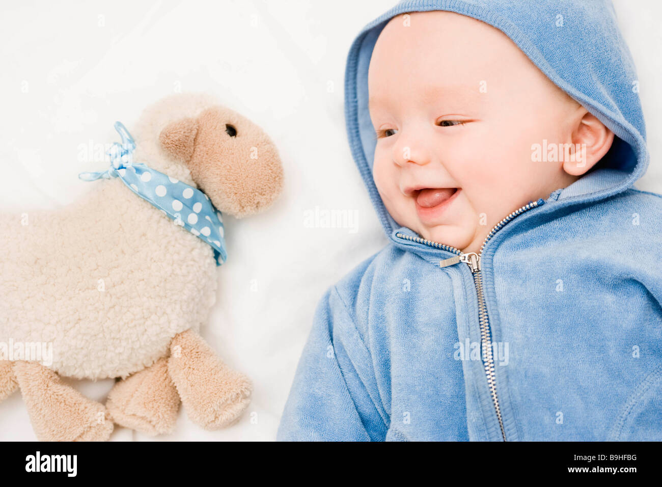Baby smiling to a sheep Stock Photo