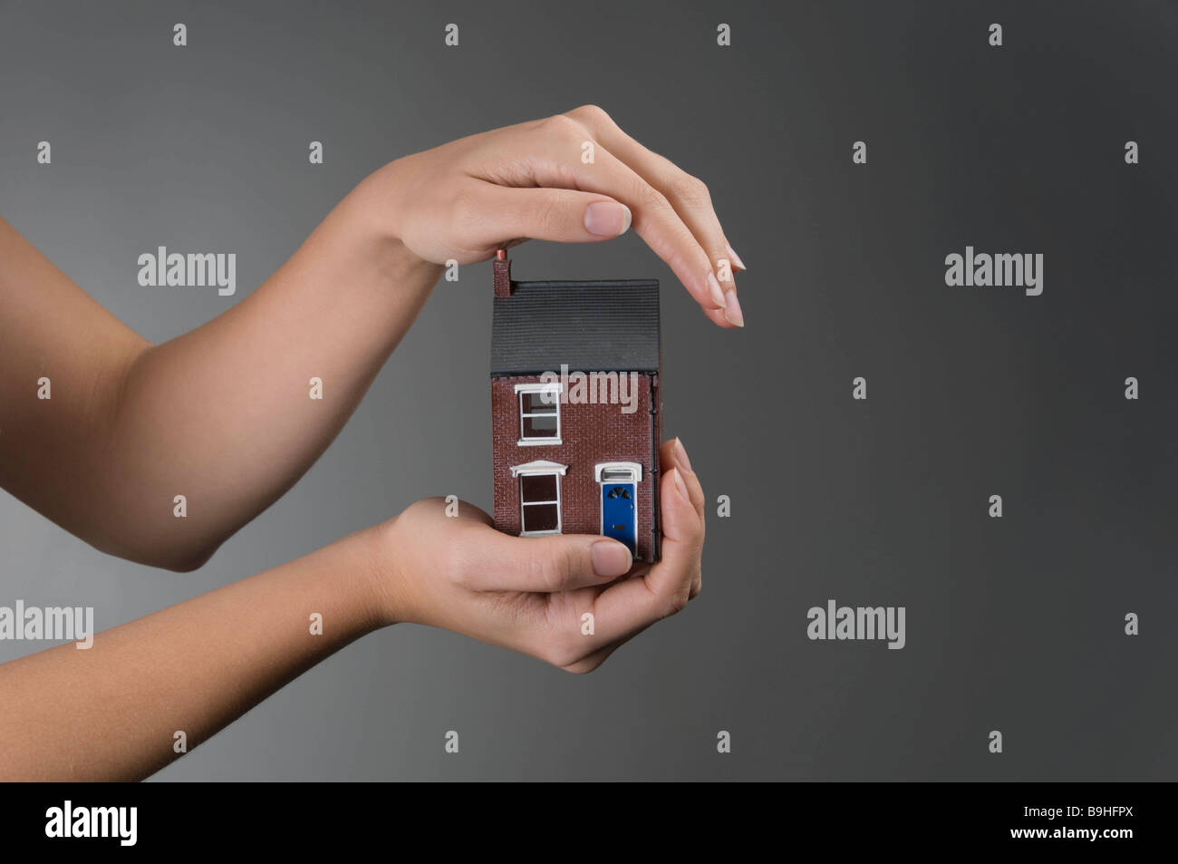 Female hands holding model house Stock Photo - Alamy