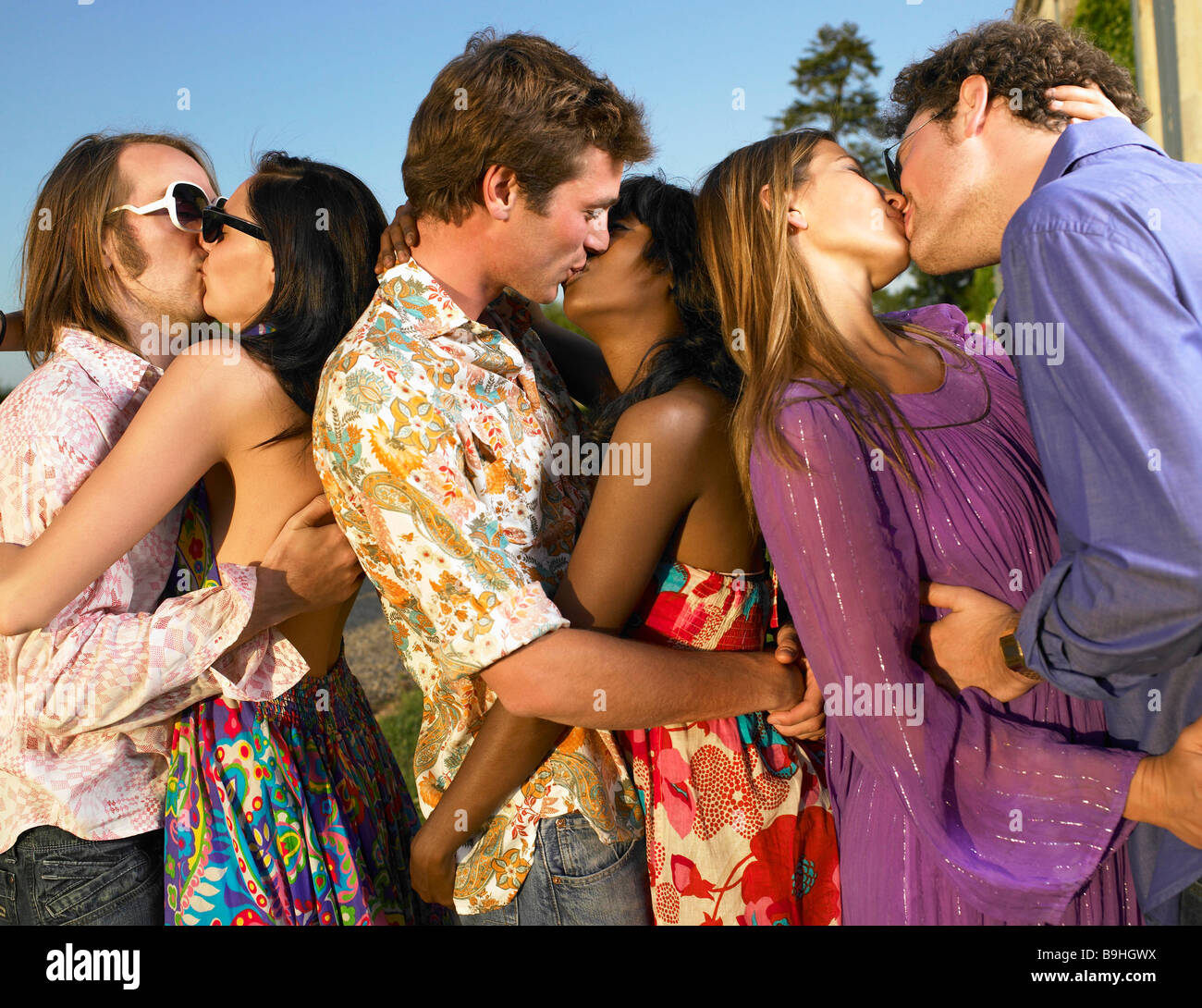 Three couples kissing at sunset Stock Photo