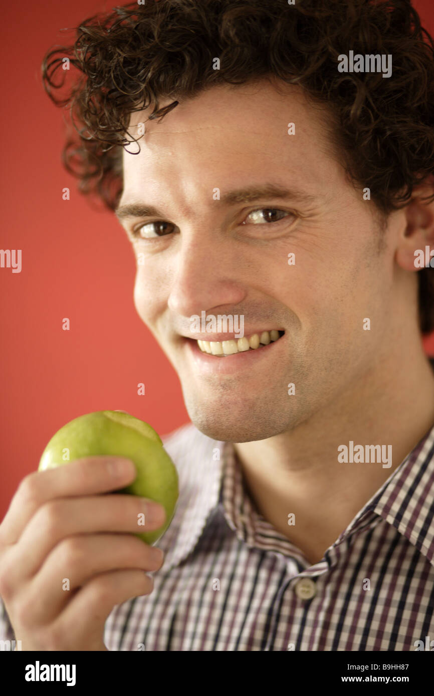 Man smiling apple eating portrait broached Stock Photo - Alamy