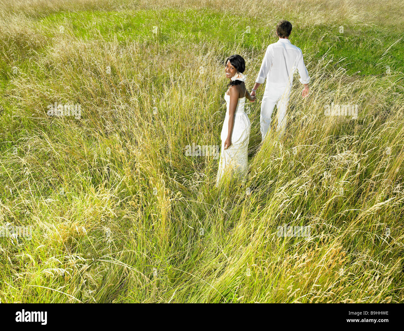 Married couple walking in a field Stock Photo - Alamy