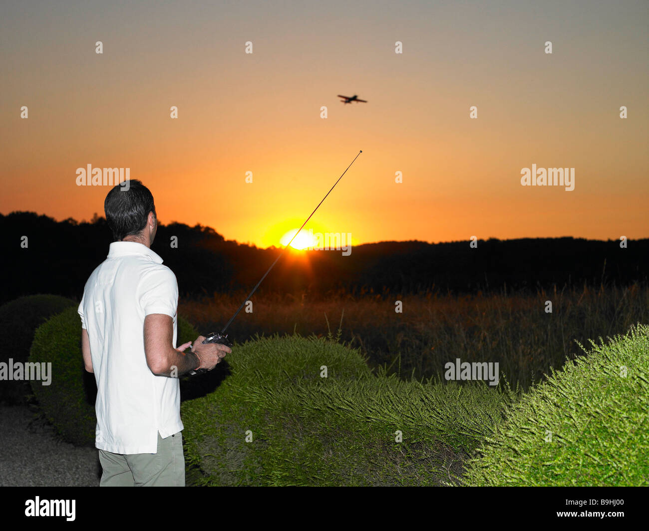 Man playing with remote-controlled plane Stock Photo