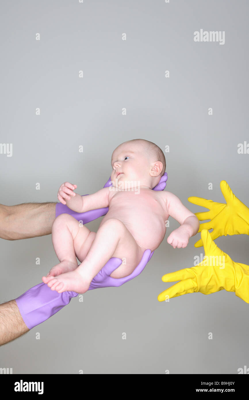 Man woman detail hands rubber gloves baby bare passes on