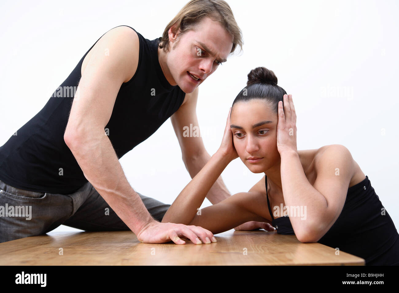 Table pair young ears people scold dispute man woman keeps closed 20-30 years 30-40 years hairdo two friends relationship Stock Photo